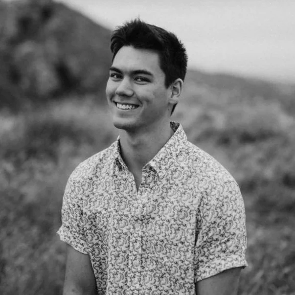 Luke, co-founder, in a black and white portrait taken outdoors.